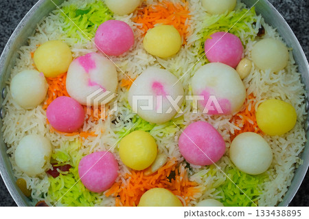 Mutanjan, sweet colored rice with rasgulla and cham cham colorful balls, almonds and marmalade, prepared for serving as niyaz. Close-up and top view of a traditional islamic festive sweet dish. Mutanjan, sweet colored rice with rasgulla and cham cham colorful balls, almonds and marmalade, prepared for serving as niyaz. Close-up and top view of a traditional islamic festive sweet dish. 133438895