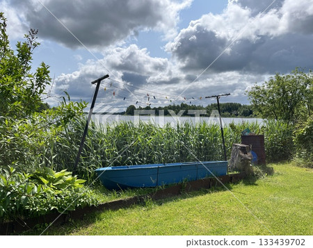 Old blue boat by the lake and clothesline with pegs outdoors 133439702