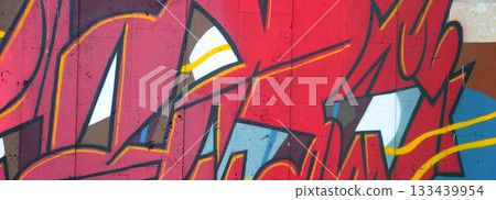 Colorful background of graffiti painting artwork with bright aerosol outlines on wall. Old school street art piece made with aerosol spray paint cans. Contemporary youth culture backdrop 133439954