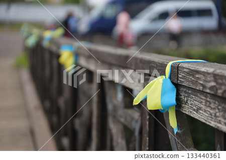 Ribbons in the colors of the national flag of Ukraine are tied to the handrail. Yellow-blue tapes Ribbons in the colors of the national flag of Ukraine are tied to the handrail. Yellow-blue tapes 133440361