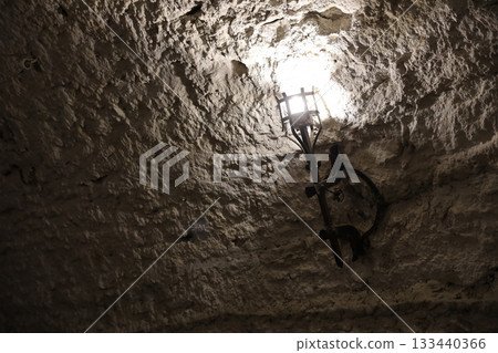 Lighted medieval castle torch hanging on a stone wall, vintage objects and background 133440366