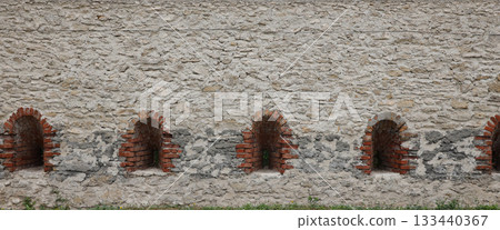 Very old window in brick stone wall of castle or fortress of 18th century. Full frame wall with window close up Very old window in brick stone wall of castle or fortress of 18th century. Full frame wall with window close up 133440367