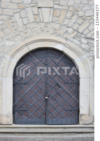 Very old solid door in brick stone wall of castle or fortress of 18th century. Full frame wall with door close up Very old solid door in brick stone wall of castle or fortress of 18th century. Full frame wall with door close up 133440377