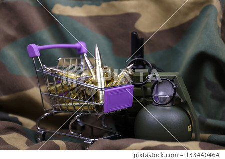 Rifle cartridges in small shopping cart. Big caliber ammo cartridges and hand grenades with a small shopping basket close up Rifle cartridges in small shopping cart. Big caliber ammo cartridges and hand grenades with a small shopping basket close up 133440464