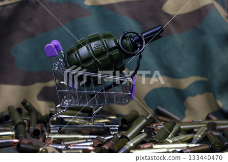 Rifle cartridges in small shopping cart. Big caliber ammo cartridges and hand grenades with a small shopping basket close up Rifle cartridges in small shopping cart. Big caliber ammo cartridges and hand grenades with a small shopping basket close up 133440470