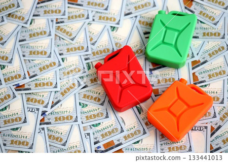 Petroleum or gasoline canister lies on big amount of dollar bills. Concept of petrol prices in United States Petroleum or gasoline canister lies on big amount of dollar bills. Concept of petrol prices in United States 133441013