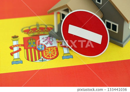 Residential house with stop sign on Spanish flag close up. Concept of Squatting in Spain. Okupas problem 133441036