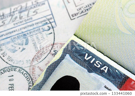 US Embassy visa in passport page with stamps on table close up US Embassy visa in passport page with stamps on table close up 133441060
