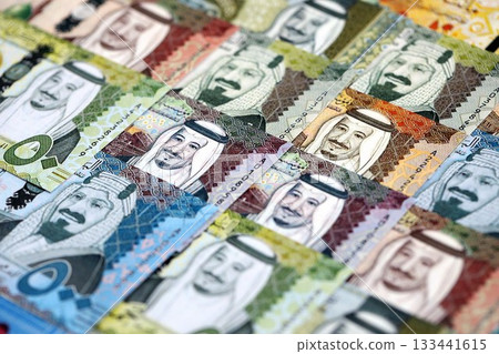 Saudi Arabia riyal money bills banknotes lies in big pile on table close up. Concept of finances and business in Saudi Arabia Saudi Arabia riyal money bills banknotes lies in big pile on table close up. Concept of finances and business in Saudi Arabia 133441615
