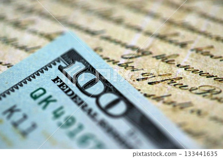 One hundred US dollar bills and United States Constitution page fragment. Concept of lawsuit and bribery in United States One hundred US dollar bills and United States Constitution page fragment. Concept of lawsuit and bribery in United States 133441635