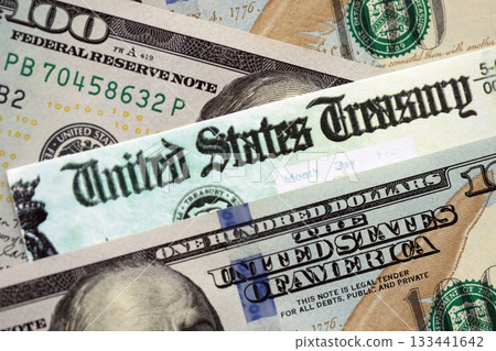 United States Treasury refund check or stimulus bill with many hundred dollars banknotes close up United States Treasury refund check or stimulus bill with many hundred dollars banknotes close up 133441642
