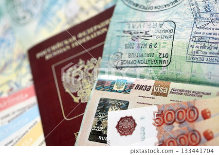 Fragment of Russian Federation visa in passport page and russian money close up. Concept of travel and tourism in Russia Fragment of Russian Federation visa in passport page and russian money close up. Concept of travel and tourism in Russia 133441704