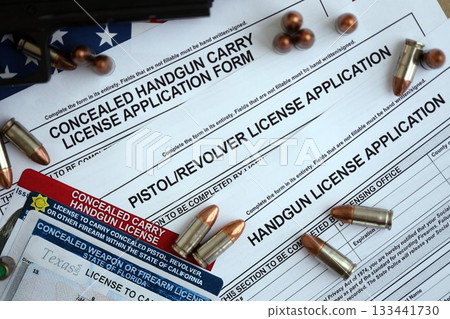 USA firearms license and handgun with bullets on US Constitution. Gun permit and Constitution second amendment concept 133441730