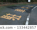 Mountain road markings and rough pavement 133442857