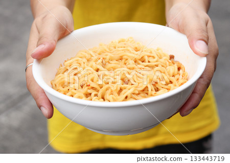 Spicy instant noodles bowl and hand Spicy instant noodles bowl and hand 133443719