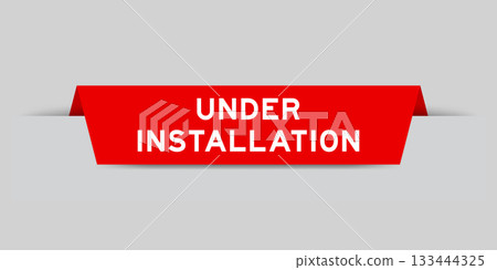 Red color inserted label with word under installation on gray background 133444325