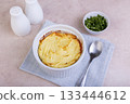 Shepherd's pie in a portioned white baking dish. Homemade traditional casserole (gratin) with minced meat and mashed potatoes. Selective focus, close-up. 133444612