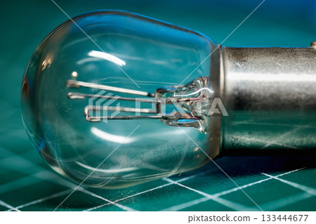 Close view of a light bulb highlighting its wires and glass. 133444677