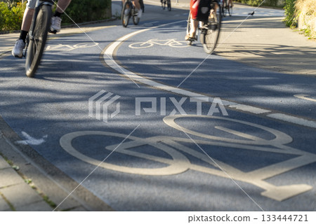 Close Up of a Bicycle Road. Blue Bike Lane With the Bicycles passing on the white symbol of a bike in Konstanz, Germany. 133444721