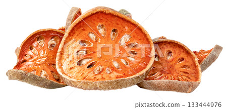 Close-up of dried bael fruit slices against. The orange, circular fruit pieces reveal their texture and seed cavities, suggesting natural ingredients and healthy food preparation. 133444976