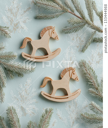 Two wooden horses on frosty evergreen branches on a soft winter background 133444988