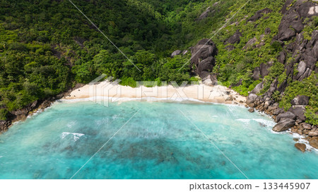 Lush hills frame a secluded, crystal clear beach. Seychelles. Anse Du Riz beach. Baie Ternay Marine National Park. 133445907