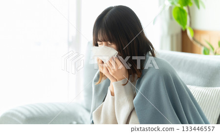 A woman with a cold and sneezing A woman with a cold and sneezing 133446557