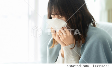 A woman with a cold and sneezing A woman with a cold and sneezing 133446558