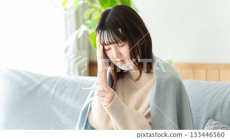 一位身體不適的女士正在測量體溫 133446560