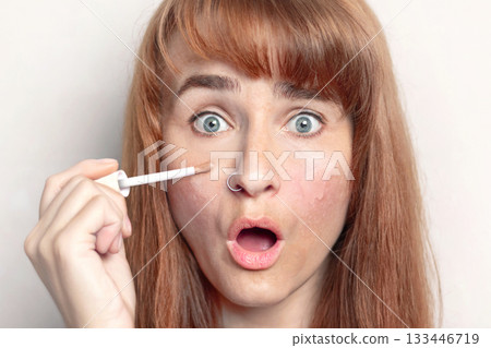 Caucasian woman is surprised that the concealer perfectly covers up dark circles under her eyes and skin imperfections. White background Caucasian woman is surprised that the concealer perfectly covers up dark circles under her eyes and skin imperfections. White background 133446719
