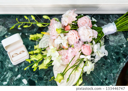 wedding rings in open box and wedding bouquet 133446747