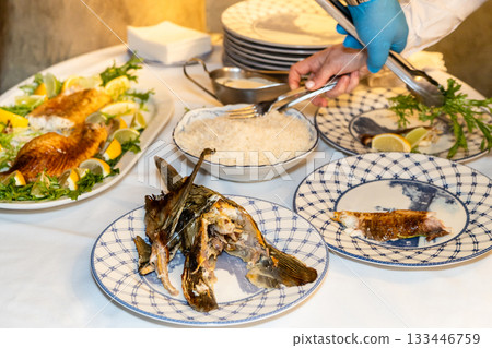 fish head on plate after cutting baked sturgeon 133446759