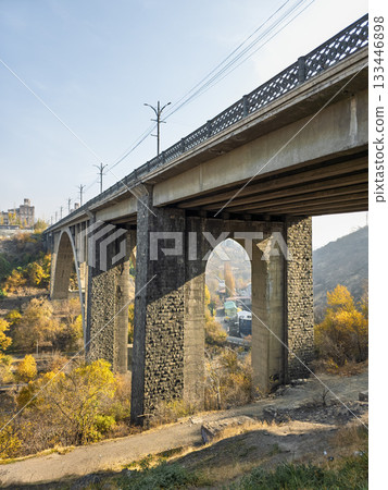 A bridge with a lot of trees and a train in the background 133446898