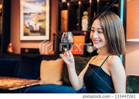 一位年輕女子在豪華餐廳裡喝紅酒 一位年輕女子在豪華餐廳裡喝紅酒 133447261