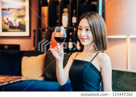 一位年輕女子在豪華餐廳裡喝紅酒 一位年輕女子在豪華餐廳裡喝紅酒 133447262