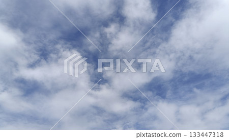 Soft blue sky with scattered white clouds and soft light creating calm atmosphere Soft blue sky with scattered white clouds and soft light creating calm atmosphere 133447318