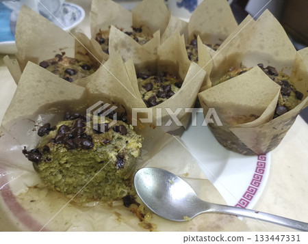 Green tea chocolate chip muffin with moist crumb and melted chips, warm homemade bakery snack 133447331