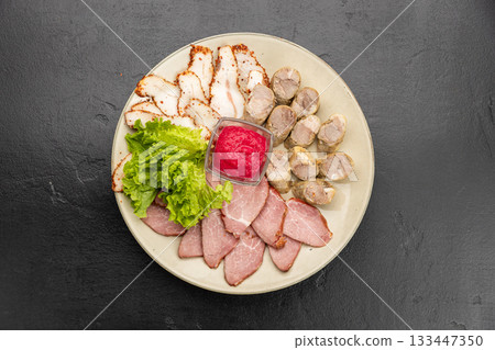 Assorted cold cuts platter with sausages, smoked pork and sauce on ceramic plate Assorted cold cuts platter with sausages, smoked pork and sauce on ceramic plate 133447350
