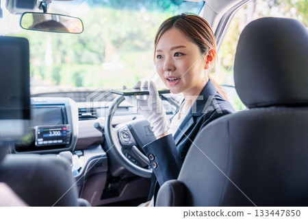 女計程車司機使用翻譯應用程式為外籍乘客提供服務。 133447850