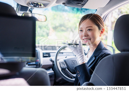 女計程車司機使用翻譯應用程式為外籍乘客提供服務。 133447851