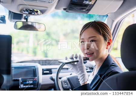 女計程車司機使用翻譯應用程式為外籍乘客提供服務。 女計程車司機使用翻譯應用程式為外籍乘客提供服務。 133447854