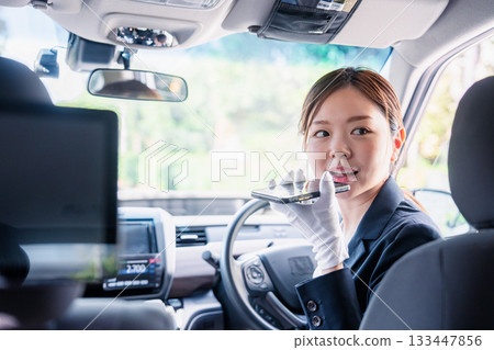 女計程車司機使用翻譯應用程式為外籍乘客提供服務。 133447856