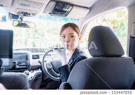 女計程車司機使用翻譯應用程式為外籍乘客提供服務。 133447858