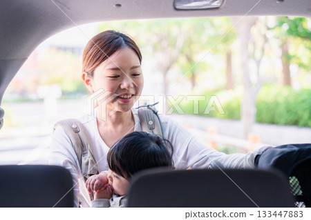 一位母親背著嬰兒背帶乘車外出。 一位母親背著嬰兒背帶乘車外出。 133447883