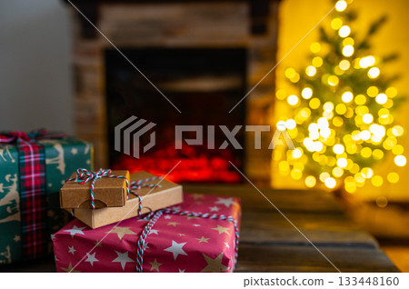 Cozy Christmas Interior with Fireplace, Gift Boxes, and Decorated Tree with Warm Lights 133448160