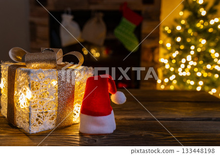 Cozy Christmas Interior with Fireplace, Gift Boxes, and Decorated Tree with Warm Lights 133448198