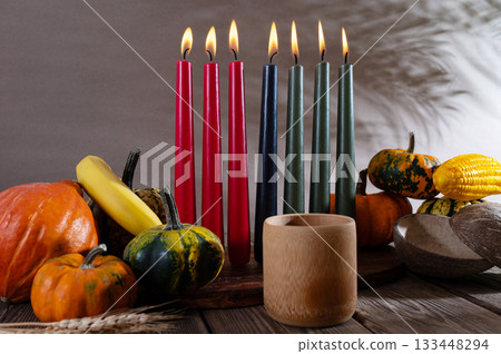 Kwanzaa, african holiday Kwanzaa with decoration of seven candles in red, black and green colors, vegetable harvest, corn. Greeting card banner. Happy Kwanzaa 133448294