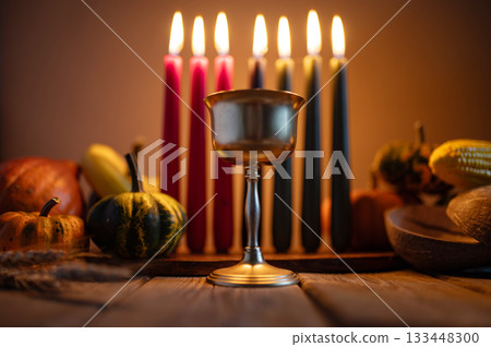 Kwanzaa, african holiday Kwanzaa with decoration of seven candles in red, black and green colors, vegetable harvest, corn. Greeting card banner. Happy Kwanzaa 133448300