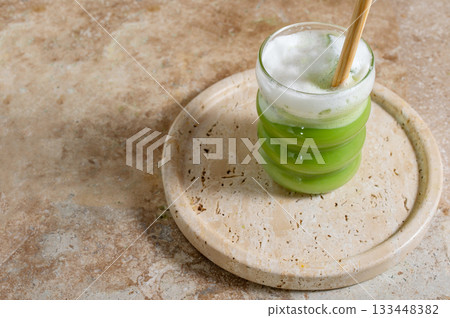 Matcha latte glass, matcha bowl, a bamboo whisk Chasen on travertine tray 133448382