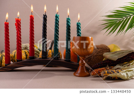 Happy Kwanzaa. Seven candles red, black and green on a natural wooden background. Harvest and gifts. Symbols of African heritage. 133448450